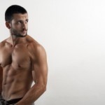 A shirtless man showing off his toned abs.