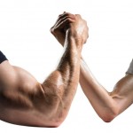 An arm wrestle between two men - one with a large arm and one with a small arm.
