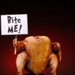 A cooked turkey holding a sign saying "Bite Me!"