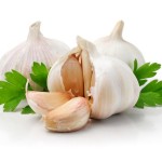 Three cloves of garlic with some parsley.