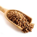 A wooden scoop full of buckwheat.
