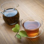 A glass pot and glass cup of tea.