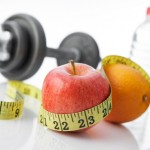 A dumbbell, tape measure, apple, orange and bottle of water.