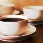 3 cups of coffee on a wooden table.