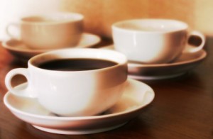 3 cups of coffee on a wooden table.