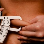 A person pinching their abdominal fat.