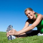 A woman stretching in a field.