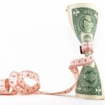 A tape measure wrapped around a paper money note.