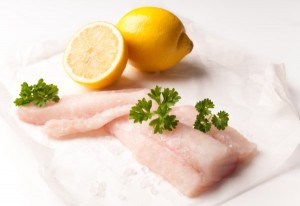 Two cod fillets with lemon and parsley.