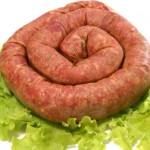 A home made sausage on a bed of lettuce.