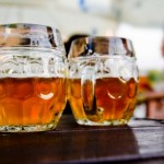 Two half pints of beer on an outdoor table.