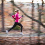 A woman running outside in the woods.