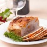 A joint of roast pork on a Christmas table.