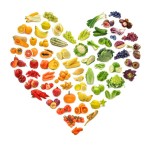 A selection of fruits and vegetables arranged in a heart shape.