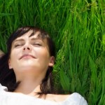 A woman relaxing lying on the grass.