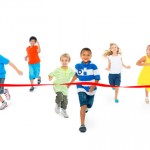 6 children running towards a finish line.